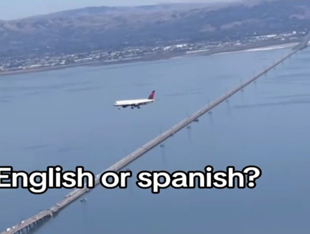 a plane frozen in the sky over a bridge with the caption "English or Spanish."